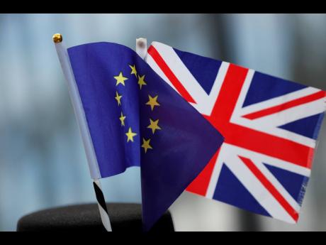 A protestor wears a hat with an EU and a Union flag as he participates in an anti-Brexit demonstration outside of an EU summit in Brussels, Thursday, Oct. 17, 2019. The European Union says Brexit negotiations are plowing on after intense talks in recent days, as EU leaders converge on Brussels for a key summit aimed at sealing a new divorce agreement. (AP Photo/Frank Augstein)