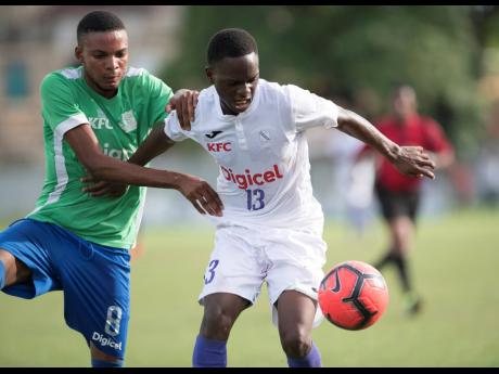 Credit: Gladstone Taylor Kingston College’s Dwayne Atkinson (right) comes under physical pressure from Vauxhall High’s Jevaun Shepherd during their second leg ISSA/Digicel Manning Cup second round fixture at Winchester Park, St George’s College, in Kingston yesterday.
