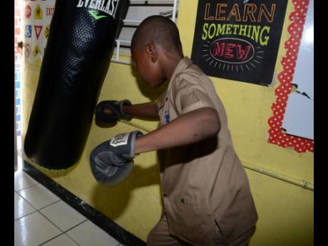 A student at St Aloysius Primary School in Kingston demonstrates how the punching bag is used as part of a therapy for pupils at the insitution.