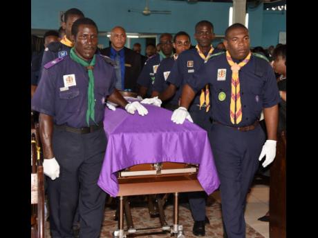 Members of the Scout Association of Jamaica wheel in the casket carrying the body of Headley Forbes yesterday during his funeral inside the St Mary The Virgin Anglican Church in St Andrew.