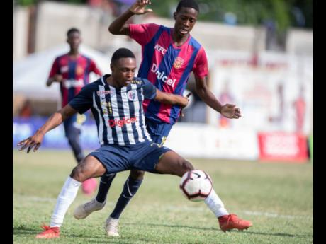 Credit: Gladstone Taylor Garrington Baker of Jamaica College (foreground) defends against Sekani Campbell of St Andrew Technical (STATHS) in their ISSA/Digicel Manning Cup quarter-final fixture at Stadium East on Tuesday, November 12, 2019. STATHS won 2-1.
