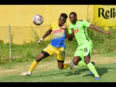 Damion Thomas (left) of Harbour View battles with Romario Campbell of Molynes United in Red Stripe Premeir League action at the Constant Spring Sports Complex yesterday. Harbour View won 1-0.