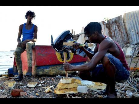 Ricardo Williams (left) and Jahvon Evans at Rae Town Fishing Village in Kingston recently.	