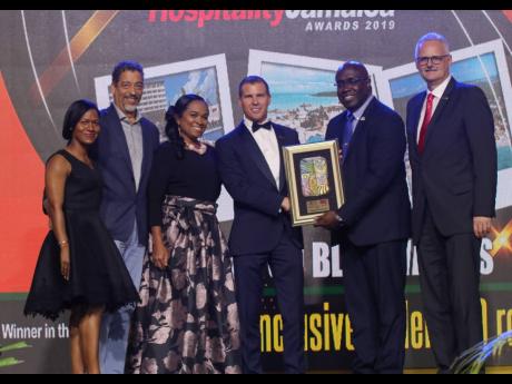 
Deputy Chairman of Sandals Resorts International Adam Stewart (third right) accepts the Best All-inclusive over 300 rooms RJRGLEANER Hospitality Jamaica Award from Gary Allen, group CEO, RJR GLEANER Communications Group. Other executives from Sandals share in the occasion.