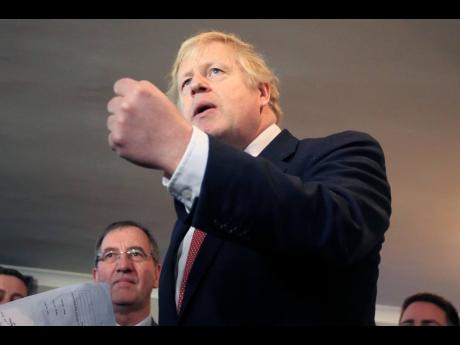Britain’s Prime Minister Boris Johnson gestures as he speaks to supporters on a visit to meet newly elected Conservative Party MP for Sedgefield, Paul Howell, at Sedgefield Cricket Club in County Durham, northeast England, on Saturday, December 14, 2019, following his Conservative party’s general election victory.  Johnson called on Britons to put years of bitter divisions over the country’s EU membership behind them as he vowed to use his resounding election victory to finally deliver Brexit. 