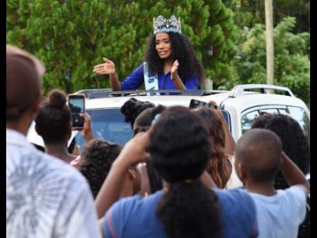 Toni-Ann Singh waves and blow kisses to excited Jamaicans who turned out to cheer her on during a motorcade through sections of her native parish yesterday.