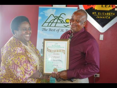 Credit: Contributed St Elizabeth Farmer Desmond Whitely (right) accepts ‘The Best of St Bess Golden Award’ from Political Ombudsman Donna Parchment Brown at the St Elizabeth Homecoming Foundation’s Homecoming Week 2019 Awards Brunch held recently at Lover’s Leap in the parish.