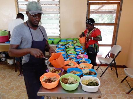 Credit: Carl Gilchrist photo A member of the CCCA sharing meals for the residents of thr St Mary Infirmary in Port Antonio on Sunday.