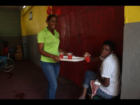 Tanisha Cowan, assistant marketing manager, JN Money Services, serves a resident of the Marie Atkins Night Shelter during a luncheon for residents of the facility.  Contributed