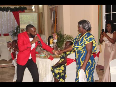 Digicel Rising Stars third-place finalist, Diel, serenades Principal of Patrick Town Early Childhood Institution, Curdel Lewis.


