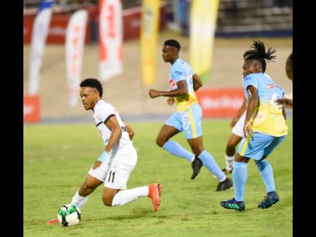 Cavalier’s Alex Marshall (left) on the offensive against Waterhouse FC during their Red Stripe Premier League semi-final match at the National Stadium in Kingston on Monday, April 8, 2019.