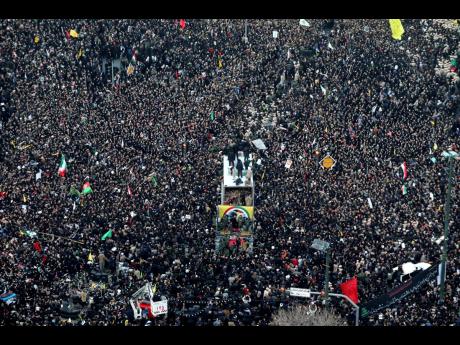Coffins of General Qassem Soleimani and others who were killed in Iraq by a US drone strike are carried on a truck surrounded by mourners during a funeral procession in the city of Mashhad, Iran, yesterday. Soleimani’s death last Friday in Iraq further heightens tensions between Tehran and Washington after months of trading attacks and threats that put the wider Middle East on edge.