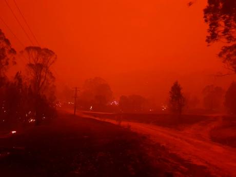 In this December 31, 2019 photo provided by Siobhan Threlfall, fire and thick smoke remains the village of Nerrigundah, Australia. 