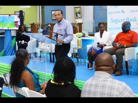 Michael Willacy, vice-president – retail, SME and corporate banking, Sagicor Bank, addresses the first staging of the Sagicor Bank Financial Enrichment Session, held last Wednesday. Also pictured are panelists (from left, background) Ingrid Wood, manager, mortgage sales and services, Sagicor Bank, Kerriann Forrester, mortgage officer, Sagicor Bank; and Orville Brown, loan officer, National Housing Trust. 