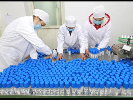 Workers pack bottles of alcohol disinfectant in a factory in Suining in southwest China’s Sichuan province yesterday.