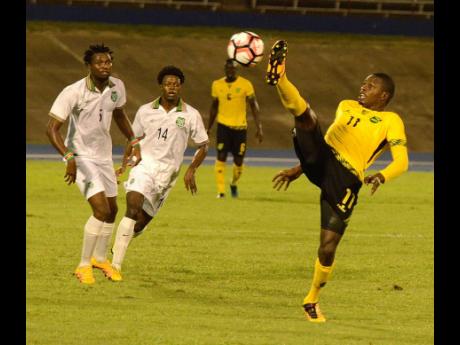 Credit: File In this November 2016 file photo, national striker Corey Burke (right) stretches high to try control the ball ahead of Guno Kwasi (left) and Sergino Eduard (centre) of Suriname during their CFU Caribbean Cup qualifier at the National Stadium in Kingston.
