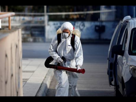 
A worker wearing a protective suit enters a primary school, where a child was diagnosed with coronavirus, to spray disinfectant, in the northern city of Thessaloniki, Greece, on Thursday, February 27. The virus has spread to several countries, raising fears it could affect global economic growth.