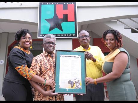 The poem “The Black African Bloom” – Tribute to Marcus Mosiah Garvey, was presented to Liberty Hall by Errol Bean (second leftl), seen in the photo are (from left) Dalea Bean, historian and gender specialist; Carey Brown, acting director, Lilberty Hall and Constance Dunkley, administrator/ programmes coordinator, Liberty Hall.