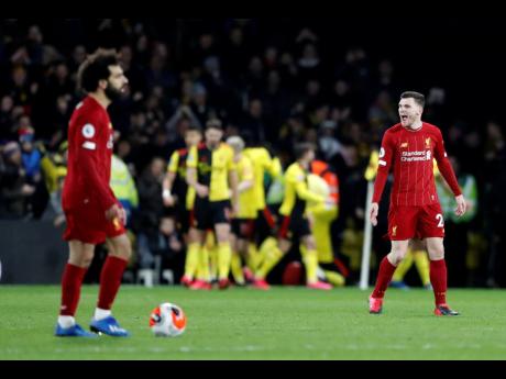 Liverpool’s Andrew Robertson (right) and teammate Mohamed Salah react after Watford’s Troy Deeney scores his side’s third goal during the English Premier League at Vicarage Road stadium in Watford, England, yesterday.