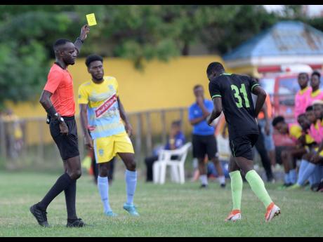 Credit: Shorn Hector Referee Oshane Nation (left) shows Molynes Defender Fakibi Farquharson (right) a yellow card moments after he committed a foul on a Waterhouse player during a Red Stripe Premier League match at the Constant Spring Sports Complex on Sunday November 3, 2019. Waterhouse won the match 2-1.