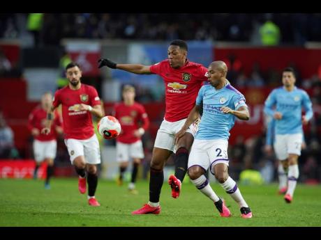 Credit: AP Manchester United’s Anthony Martial (centre) and Manchester City’s Fernandinho compete for the ball during the English Premier League match between Manchester United and Manchester City at Old Trafford in Manchester, England, yesterday. Martial opened the scoring as United won 2-0.