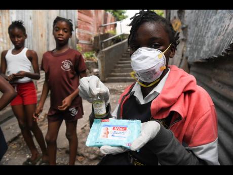 Kimara Butler of Board Villa, Kingston, is battle-ready with a bottle of rubbing alcohol and hand sanitiser. 