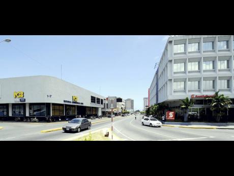 Banks sit on opposite sides of the entrance to the business district of New Kingston.