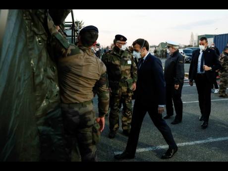 French President Emmanuel Macron wears a face mask during a visit at the military field hospital in Mulhouse, eastern France, yesterday.