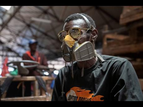 A cart operator is all geared up against the COVID-19 coronavirus. Jamaicans out in public and in the workplace are donning protective gear as the virus spreads.