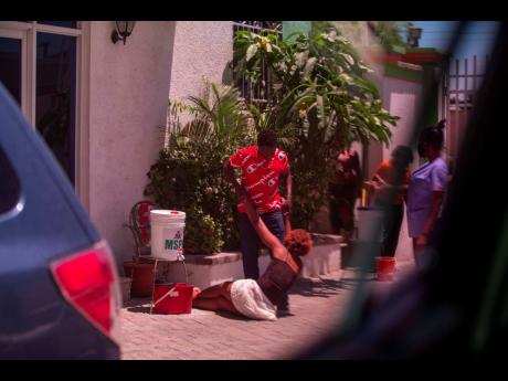 A man who was deported from the United States and who tested positive for the new coronavirus is stopped by his girlfriend after the police shot in the air to prevent him from leaving the hotel he is being quarantined in, in Tabari, Haiti. 