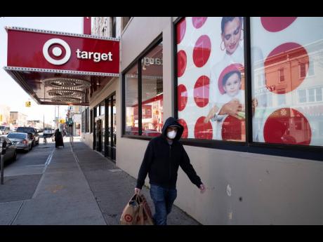 Credit: AP A customer wearing a mask carries his purchases as he leaves a Target store on April 6, 2020, in the Brooklyn borough of New York.