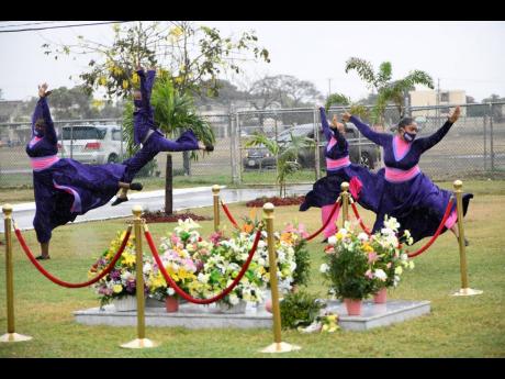 A Tivoli dance group performs in the rain in tribute to the late Edward Seaga at his tomb on Thursday. A floral tribute was laid at National Heroes Park on the first anniversary of Seaga's passing. 