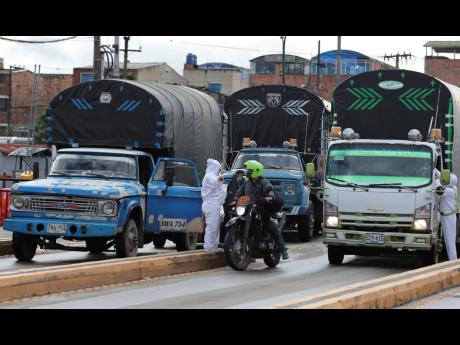 Workers of the Corabastos market, one of Latin America’s largest food distribution centres, take the temperature of drivers due to the presence of the new coronavirus, in the Kennedy area of Bogota, Colombia, on Monday, June 1, 2020. 