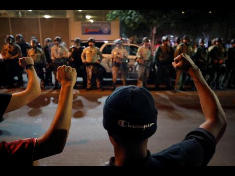 Protesters raise their fists during a rally in Las Vegas on Monday over the death of George Floyd, a black man who died in police custody in Minneapolis. 