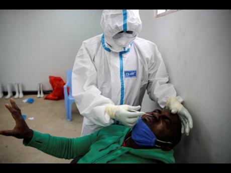 In this photo taken Monday, June 1, 2020, a Tanzanian truck driver reacts as he is tested for the coronavirus on the Kenya side of the Namanga border crossing with Tanzania. 