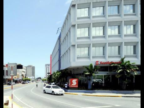 A car drives by a Scotiabank branch in New Kingston.