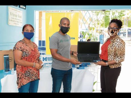 Travis Graham (centre), executive director, Oracabessa Foundation, hands over two laptops to Natricia Lothian (right), principal, Oracabessa Primary and High School. NCB Foundation has partnered with Oracabessa Foundation to assist its COVID-19 Education S