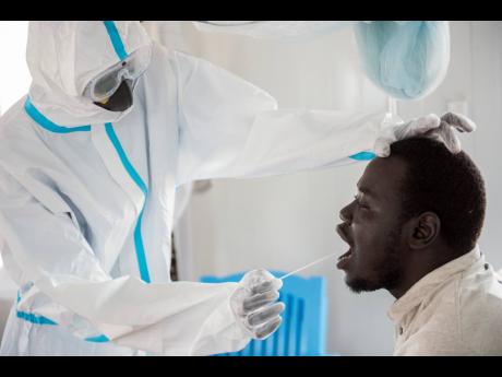An infectious disease specialist, Dr Reagan Taban Augustino (right), now a coronavirus patient himself under quarantine at the Dr John Garang Infectious Diseases Unit in Juba, South Sudan. 
