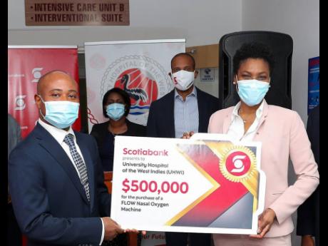 Credit: Contributed Audrey Tugwell Henry (right), executive vice-president of Retail Banking, presents an additional donation of $500,000 to fund the purchase of a Flow Nasal Oxygen Machine which can help to improve the outcome of persons requiring respiratory treatment and p