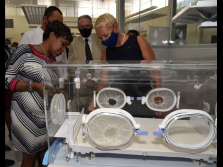 Dr Jacqueline Wright-James (left) chief medical officer, Spanish Town Hospital, explains the functions of the incubator and its importance to the new high-dependency units (HDUs) to Dr Christopher Tufton (second left), minister of health and wellness. Look