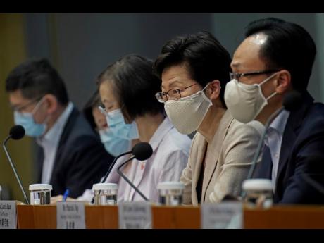 Hong Kong Chief Executive Carrie Lam (second from right) listens to reporters’ questions during a press conference held in Hong Kong, Sunday, July 19, 2020. Lam introduced renewed anti-virus measures Sunday, saying the southern Chinese city’s situation