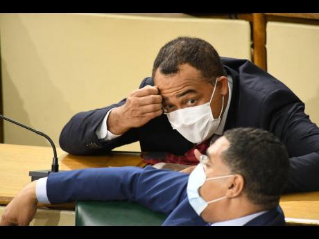 Credit: Rudolph Brown/Photographer Prime Minister Andrew Holness engages in a tête-à-tête with Dr Christopher Tufton, the minister of health and wellness, during a sitting of the House of Representatives on Tuesday. The ministry published reams of documents accounting for its relationshi