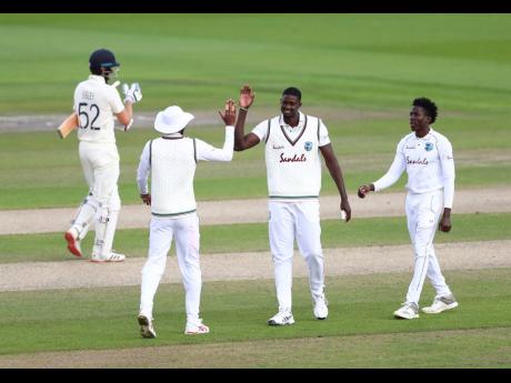 Credit: AP West Indies’ captain Jason Holder (second right) celebrates with teammates the dismissal of England’s Dom Sibley (left) during the third day of the third cricket Test match between England and West Indies at Old Trafford in Manchester, England, on Sund