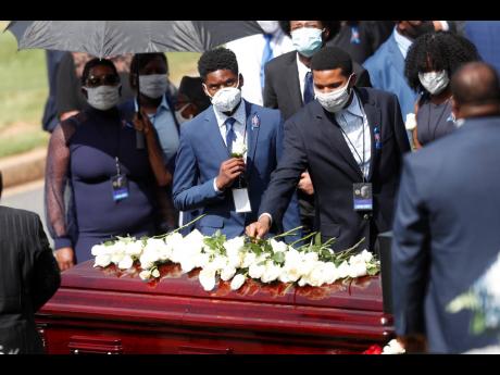 Credit: AP Mourners place flowers on the casket of Rep John Lewis at South-View Cemetery, yesterday, in Atlanta. Lewis, who carried the struggle against racial discrimination from Southern battlegrounds of the 1960s to the halls of Congress, died on July 17.