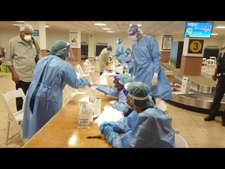 A traveller being processed by COVID-19 healthcare personnel in the immigration hall of the Sangster International Airport in Montego Bay, St James, in July.