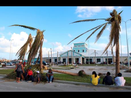 A number of extreme hurricane events have impacted Caribbean islands over recent years. Here, people sit under broken palm trees outside the Leonard M. Thompson International Airport after the passing of Hurricane Dorian in Marsh Harbour, Abaco Islands, Ba