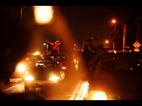 Credit: AP A person in a car raises her fist in solidarity with a march protesting the Sunday police shooting of Jacob Blake in Kenosha, Wisconsin, on Wednesday.