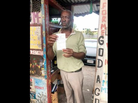 Everton ‘Shut’ Richards displays a copy of a receipt he received from the Constant Spring police after reporting at least three break-ins at his stall on Mannings Hill Road in St Andrew.