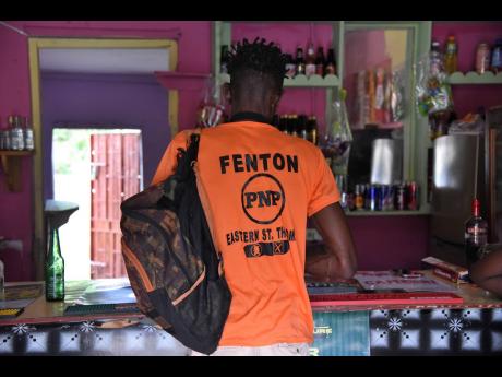 Credit: Ian Allen/Photographer A Fenton Ferguson supporter stops at a bar in Duckenfield, St Thomas Eastern, on Saturday. Ferguson will challenge Dr Michelle Charles for the seat on September 3.