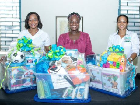 Mischa McLeod Hines (left), assistant vice-president, Capital Markets, Sagicor Investments, and Alicia Bogues (right), head of Marketing and Regional Development, CB Foods, join Debbie Dunn-Ferguson, administrator for the Maxfield Park Children’s Home, f